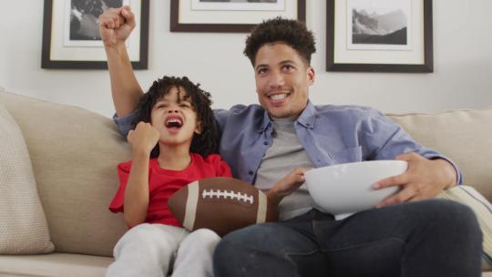和他的儿子一起看美式足球比赛视频素材模板下载