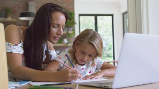 女人帮助女儿做作业