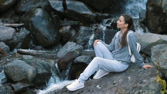 3078_一位妇女在森林的瀑布旁放松