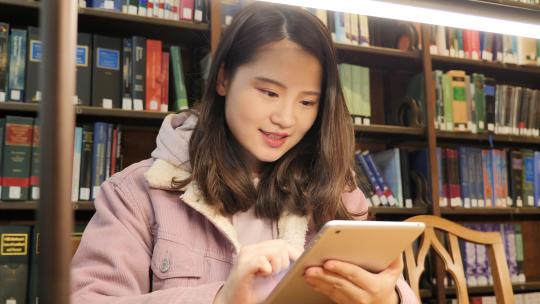 女留学生在图书馆使用电子设备学习视频素材模板下载