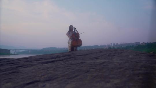 美女江边拉大提琴
