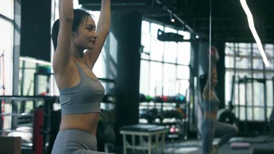 女性穿运动内衣在健身房使用哑铃锻炼视频素材模板下载
