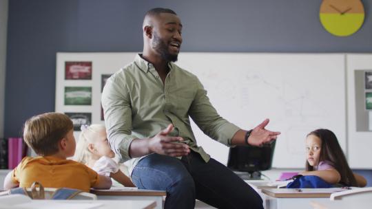快乐的非裔美国男老师在不同学生的课堂上的视频