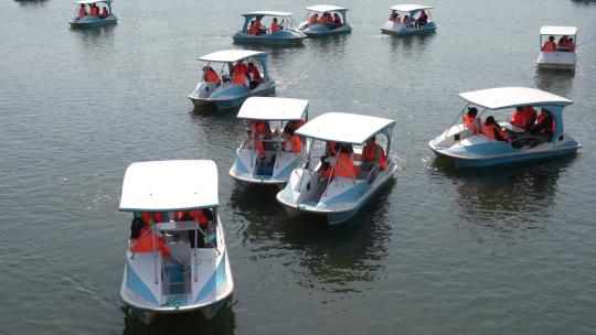 节假日，公园的水湖里，家人小孩划船