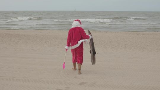 圣诞装的人赤脚走在沙滩上