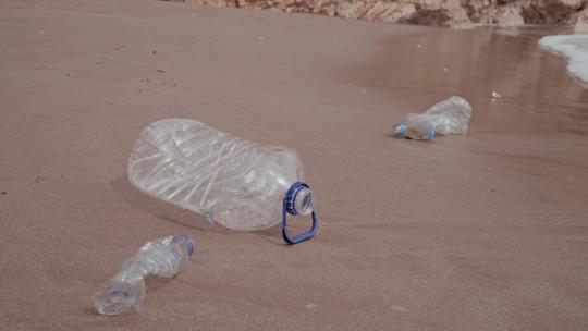 海滩上的塑料瓶和海浪