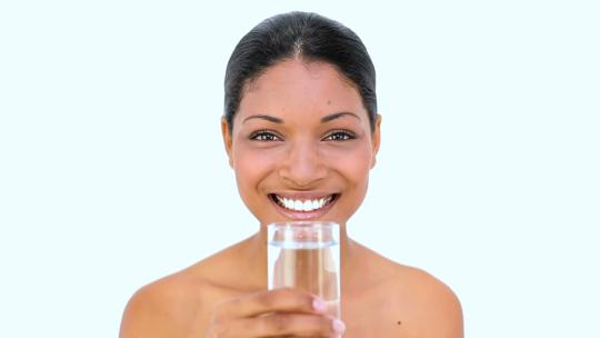 非裔女性用玻璃杯喝水