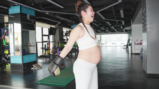怀孕的现代女性在健身房锻炼身体打拳击
