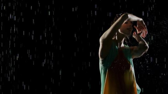 美丽的女人在雨中跳舞