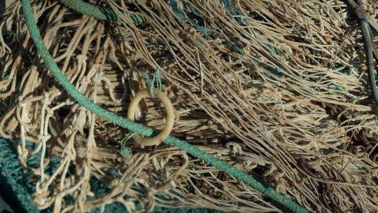 小船上堆积和缠绕的渔网的特写镜头。