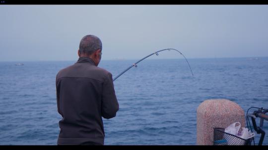 孤独老人海边钓鱼顺利钓到小鱼烟台大海风光