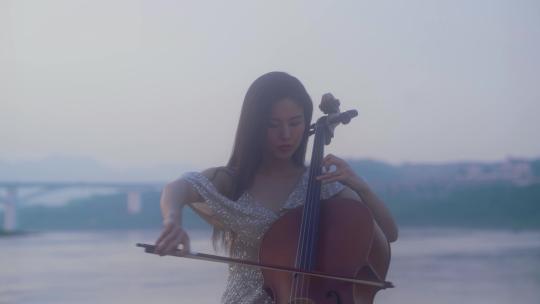 美女江边拉大提琴视频素材模板下载