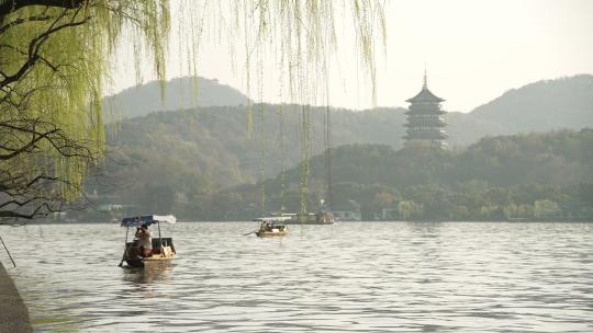 杭州西湖手摇船驶过远处是雷峰塔