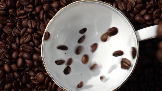 香浓咖啡豆掉落在咖啡杯里