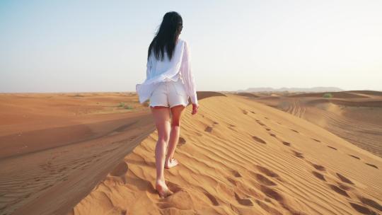 在沙丘上行走的女人