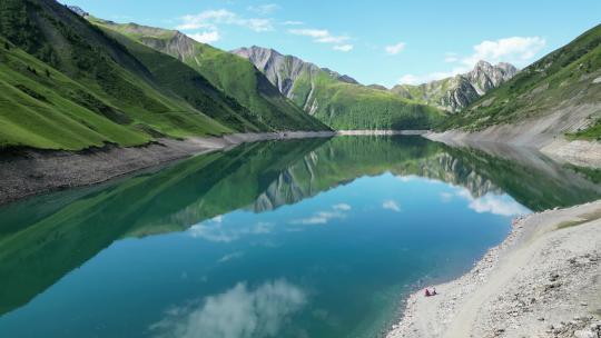 人们在法国阿尔卑斯山的Lac de Grand Maison山湖放松-空中多莉前进
