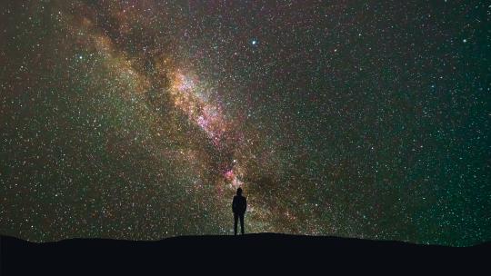男人站在银河系的背景上