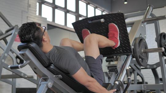 男子在健身房进行腿部肌肉锻炼
