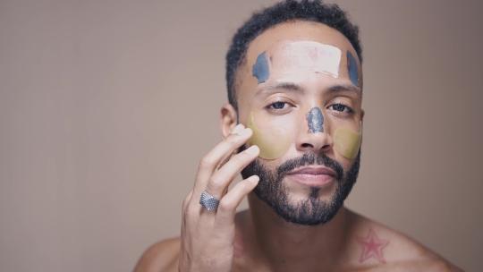 男人用美容产品来护理他的皮肤视频素材模板下载