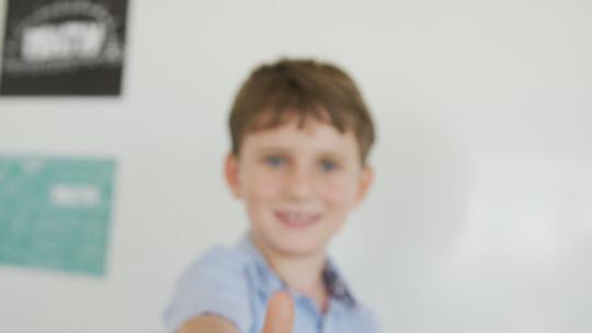 男孩在教室里竖起大拇指视频素材模板下载