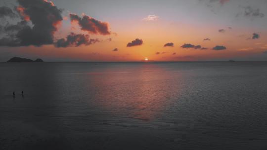 日落时沿着海滩的空中飞行