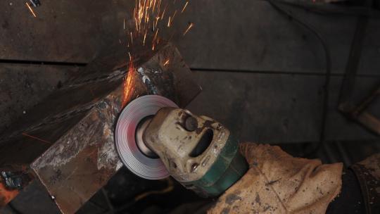工人戴手套用砂轮打磨铁器特写镜头