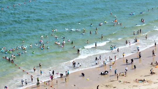航拍广东惠州大亚湾海岸沙滩冲浪游泳人群