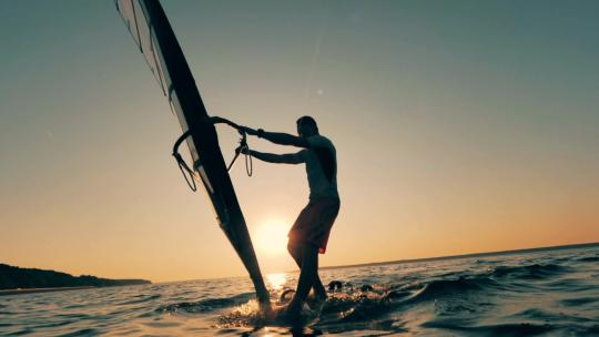 夕阳下在海上玩帆板的人视频素材模板下载
