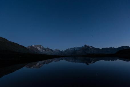 夜晚下的湖泊山脉斗转星移昼夜交替延时摄影