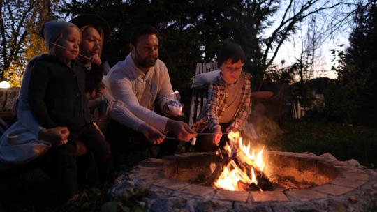 一个幸福的美国家庭的肖像。他们围坐在炉火旁烤棉花糖视频素材模板下载
