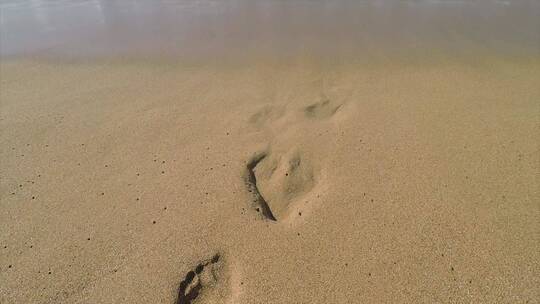 海浪冲刷着沙滩上的脚印