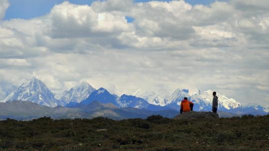 四川甘孜贡嘎雪山群峰前观景的游客