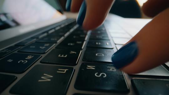 一个女孩在笔记本电脑键盘上打字的特写镜头