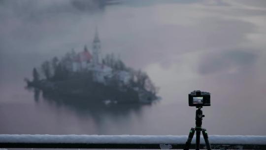 三脚架上的相机在拍摄湖岛图