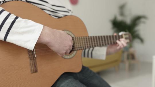 特写年轻人在家放松时弹吉他视频素材模板下载