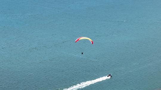 航拍蓝色大海上飞翔的滑翔伞极限运动