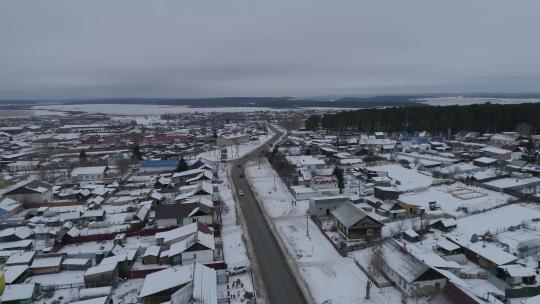 客车在冬季村庄的路上行驶