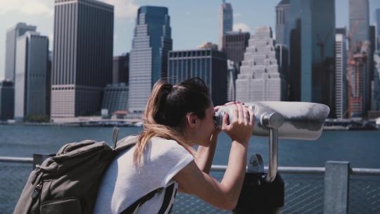 女孩用观景镜看纽约曼哈顿城市景观