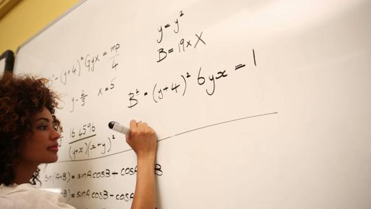 一名女人在白板上做数学题视频素材模板下载