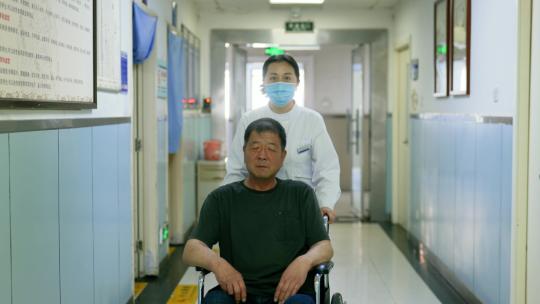 护士推着轮椅上的病人走在走廊里