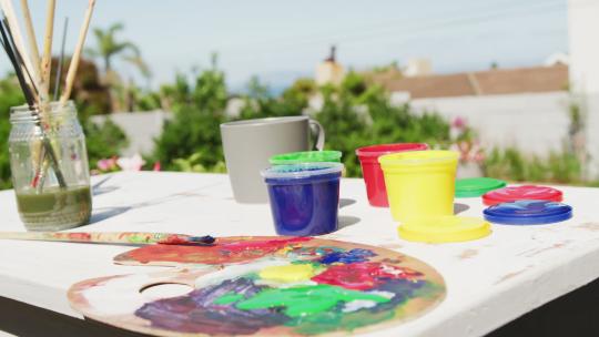 花园里桌子上彩色油漆和绘画设备的特写