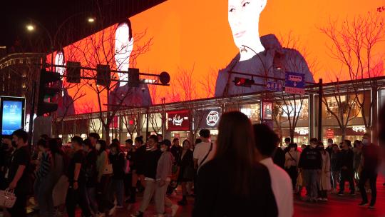 杭州延安路夜晚街道上大型宣传广告屏前人流