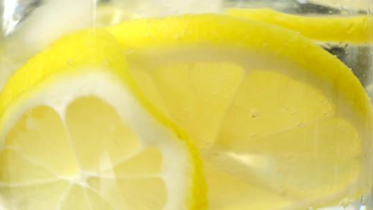 黄色的柠檬水加冰块特写镜头慢动作视频素材模板下载