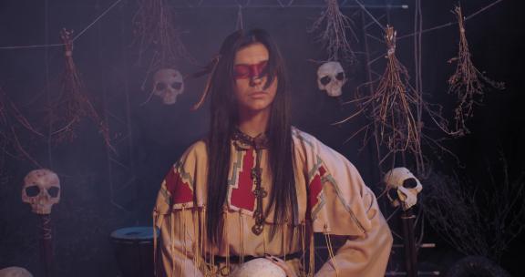 穿着传统服装的美国土著妇女站在烟雾中，