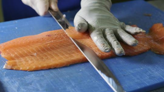 厨师切新鲜鲑鱼肉的特写镜头