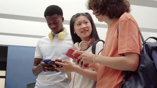 一群不同种族的学生使用手机