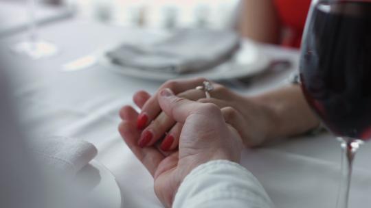 年轻夫妇在餐馆里手牵着手。