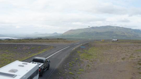白天，冰岛维斯峡湾乡下沥青路上行驶的车辆。天线视频素材模板下载