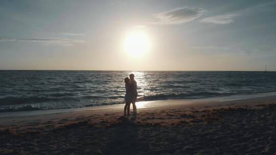 一对浪漫的夫妇在海边看日落