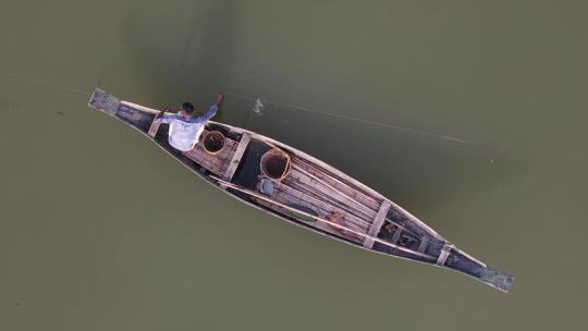 漂浮在伊查马蒂河上的传统木船上孤独渔夫的俯视图